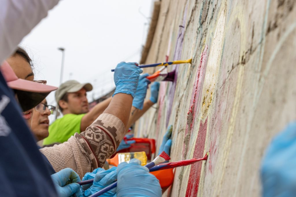 Voluntarios de Parque del Recuerdo pintando un muro en San Juan de Miraflores, Lima.