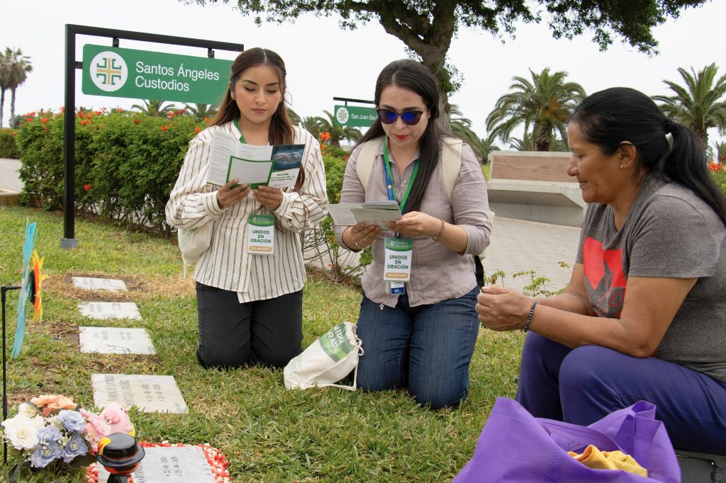 Dos colaboradoras rezando con una visitante en el Camposanto Parque del Recuerdo de Lurín durante la Semana de la Consolación 2026